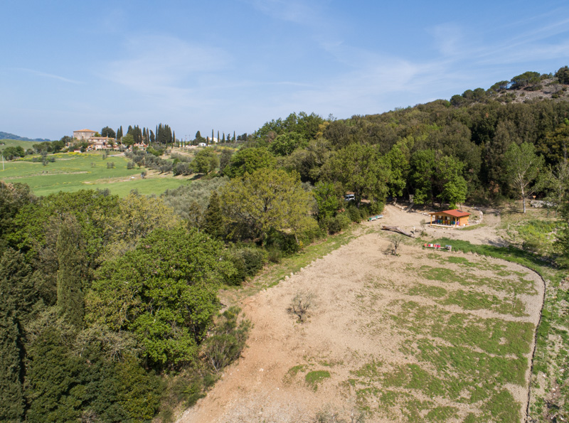 Vista aerea dell'apiario nel contesto verde con l'agriturismo in lontananza